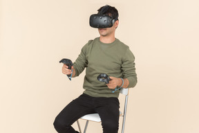 Young caucasian guy playing a virtual reality game