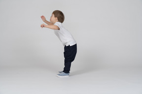 Vista lateral de un niño inclinado hacia adelante