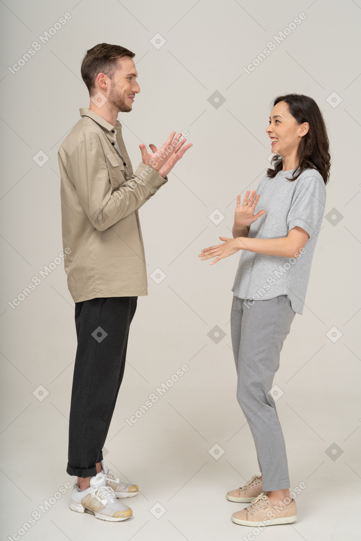 Вид сбоку на молодую пару, разговаривающую друг с другом