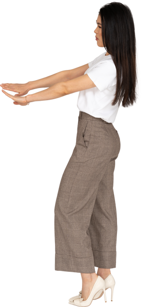 Vista lateral de una mujer joven en calzones extendiendo sus manos