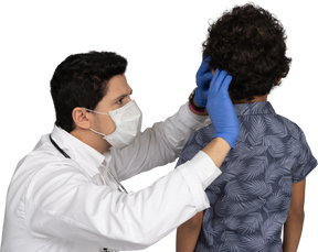 Médico examinando cabelo de menino