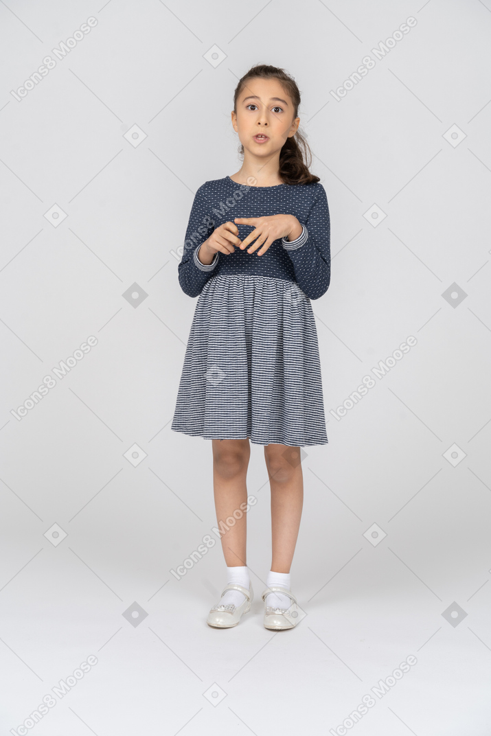 Vue de face d'une fille jouant avec ses doigts tout en parlant