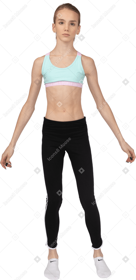 Front view of a teen girl in sportswear looking straight and outspreading hands