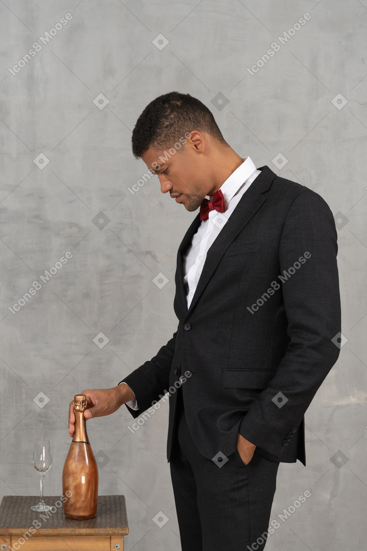Man placing a champagne bottle next to a flute glass