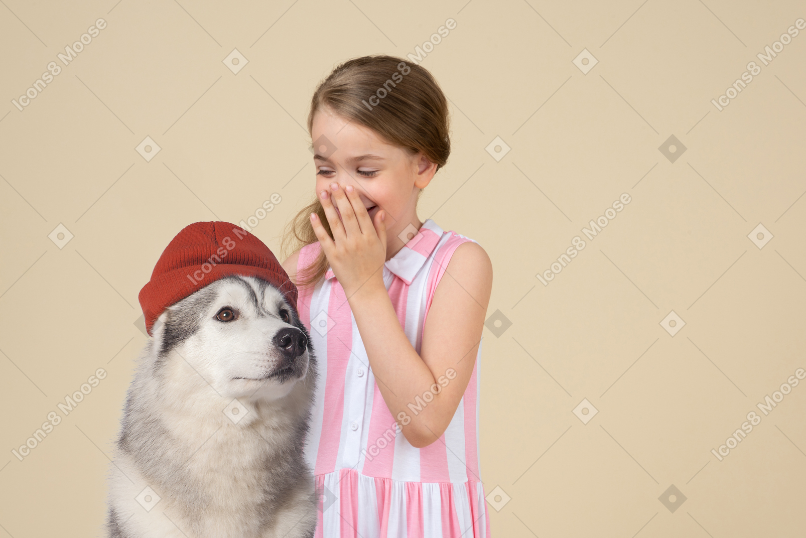 Cute little girl and a husky dog wearing a hat
