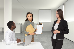 A group of people standing around a table with a laptop