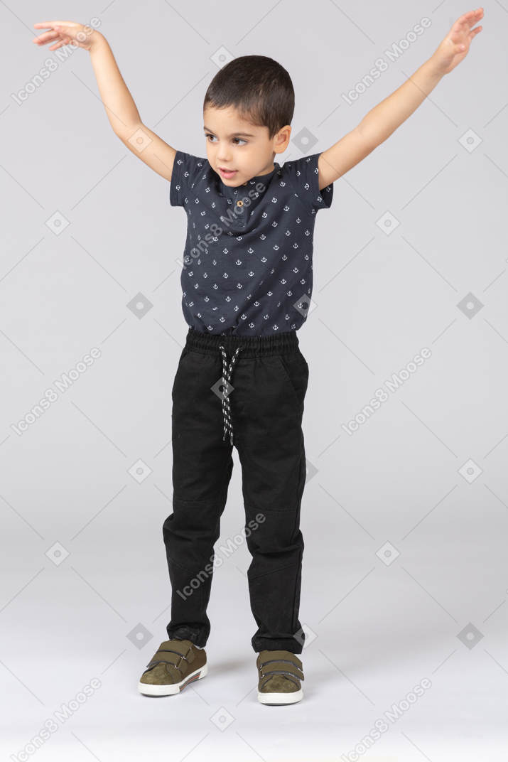 Front view of a cute boy standing with raised arms