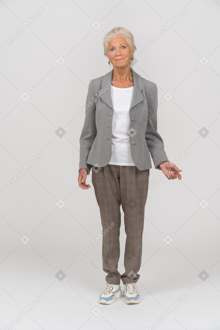 Vista frontal de uma senhora de vestido cinza olhando para a câmera