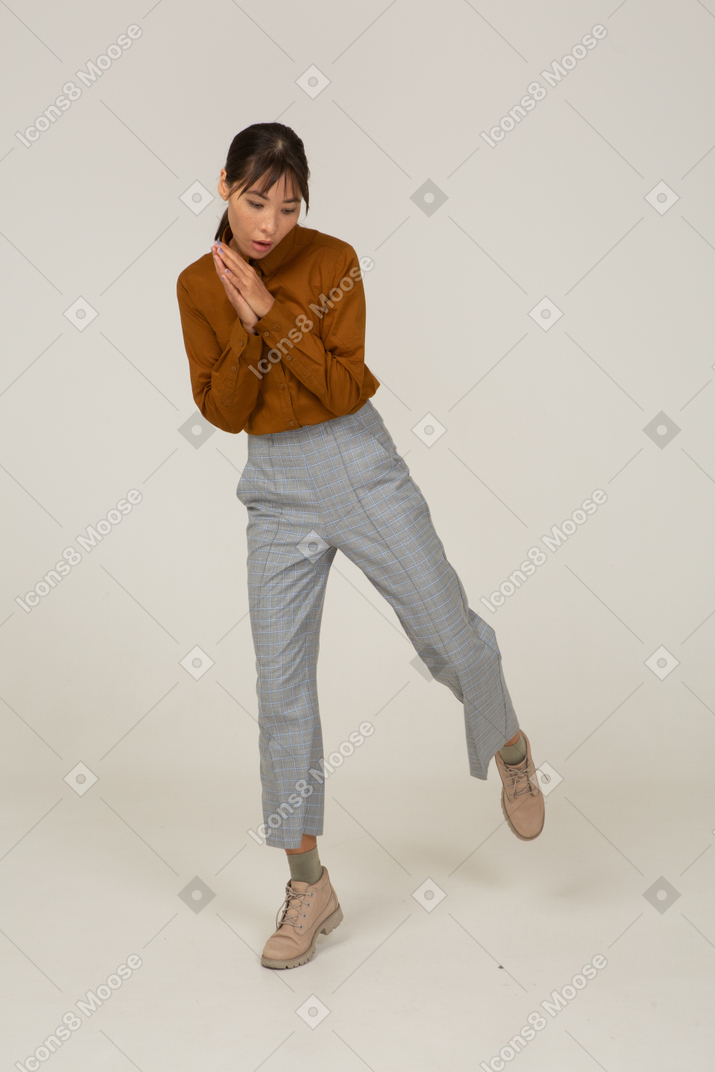 Vista frontal de uma jovem mulher asiática de calça e blusa de mãos dadas