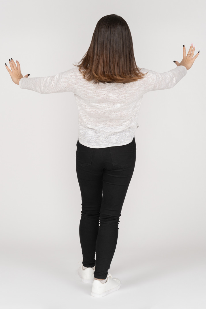 Unrecognizable brunette woman standing with outstretched arms