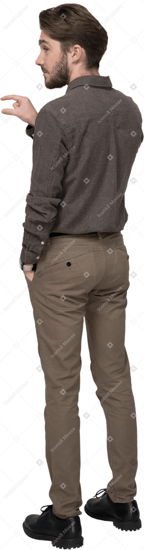 Vue de trois quarts arrière d'un jeune homme en tenue de bureau montrant la taille de quelque chose