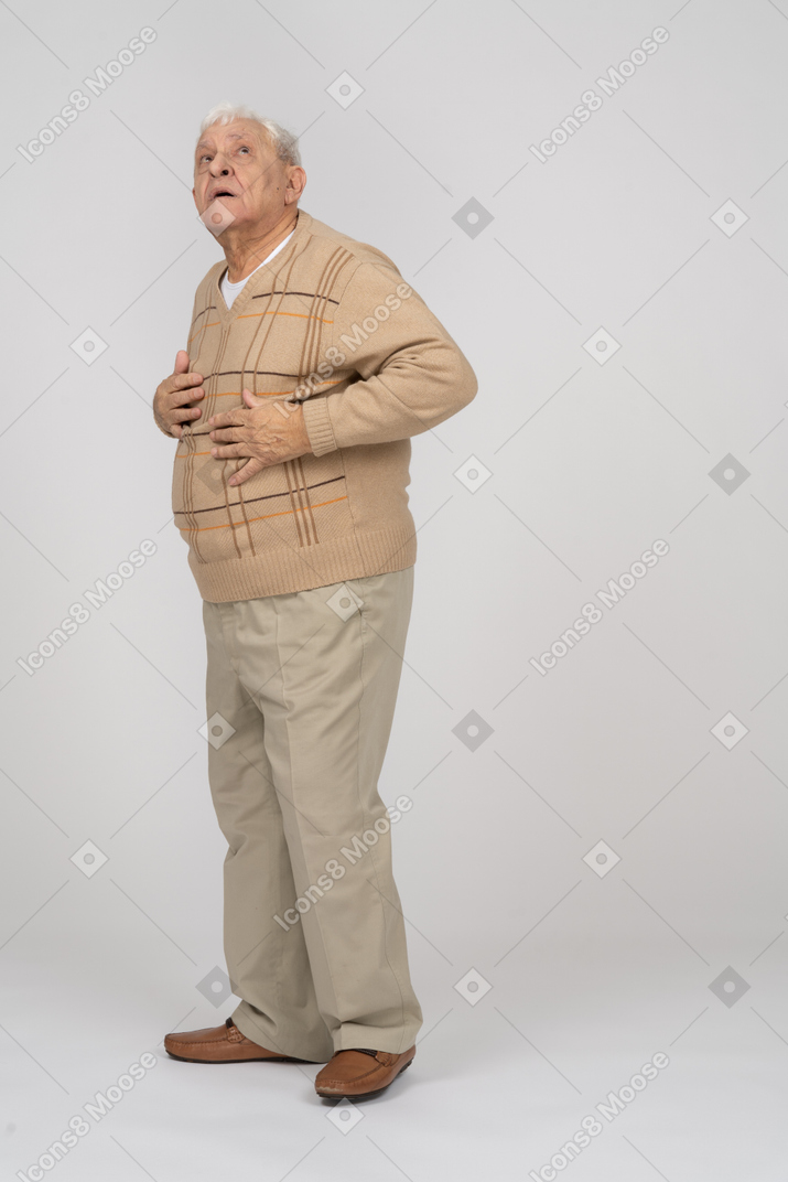 Front view of an impressed old man in casual clothes looking up