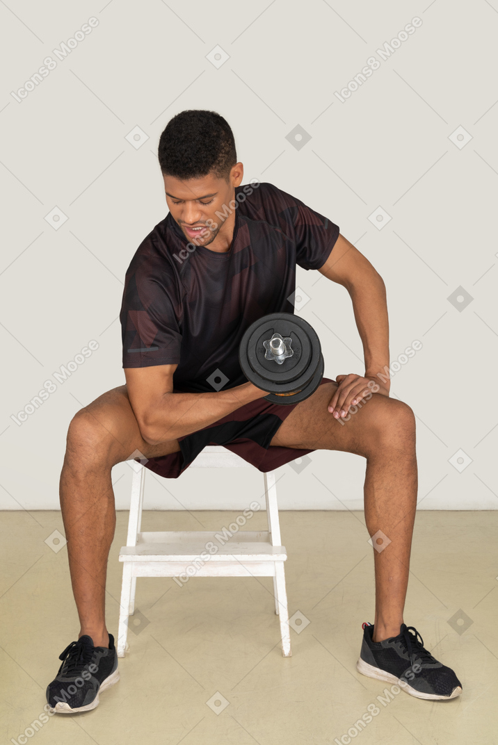 Young man in sports clothes lifting weights