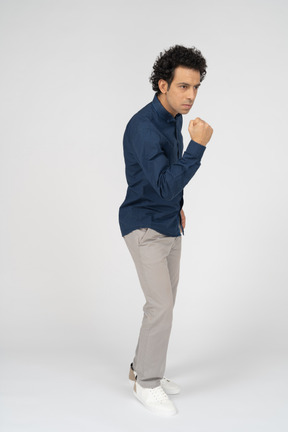 Vista frontal de um homem com roupas casuais mostrando o punho