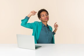 Smiling young female office worker sitting at the table