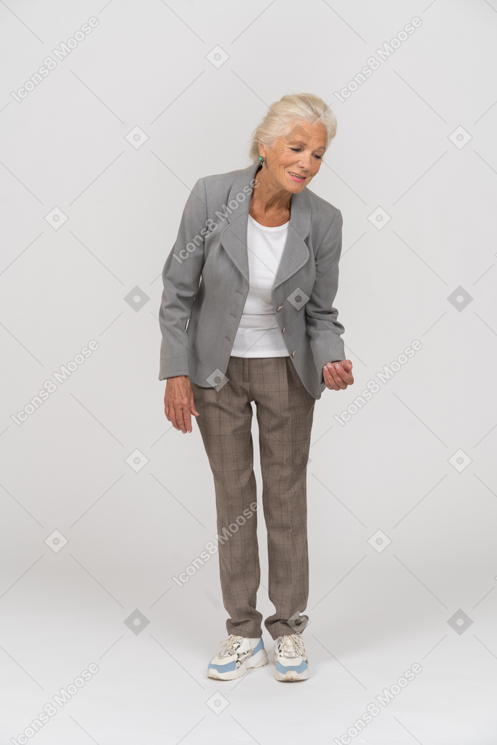 Front view of an old lady in suit explaining something