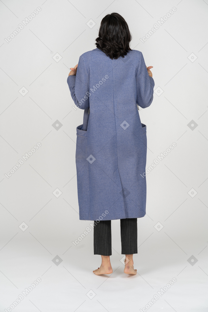 Vue arrière d'une femme excitée dans un manteau
