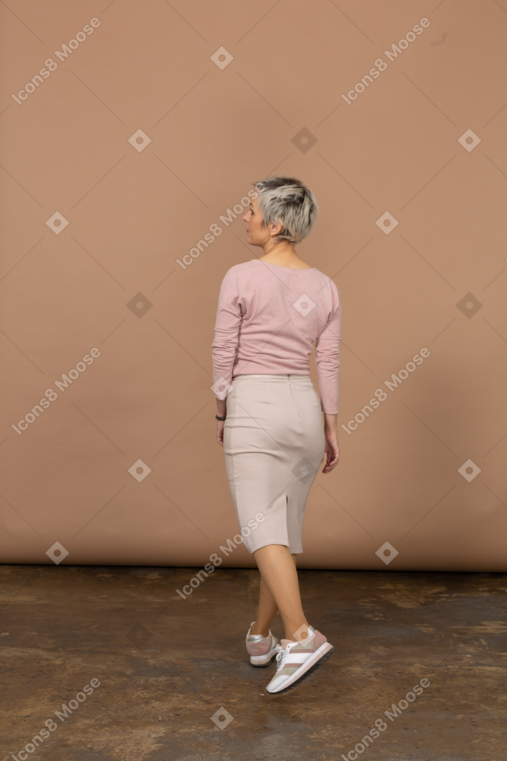 Vista posteriore di una donna in abiti casual che cammina