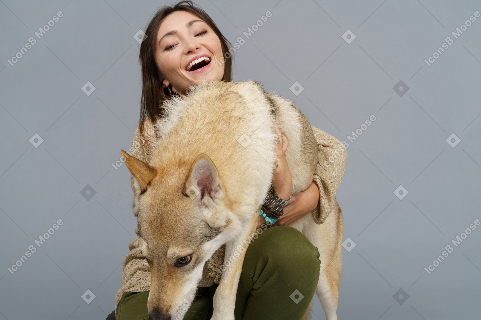 Close-up of a female master smiling and embracing her dog