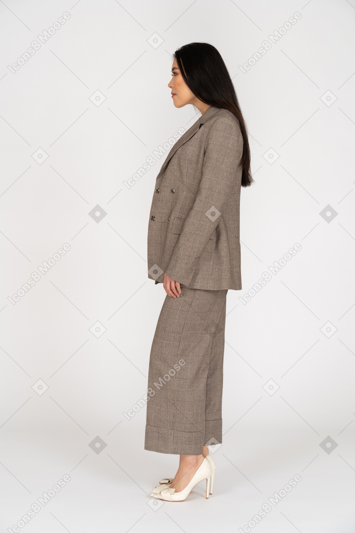 茶色のビジネススーツを着た若い女性の側面図