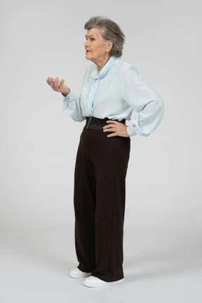 Vista de tres cuartos de una anciana gesticulando en cuestión