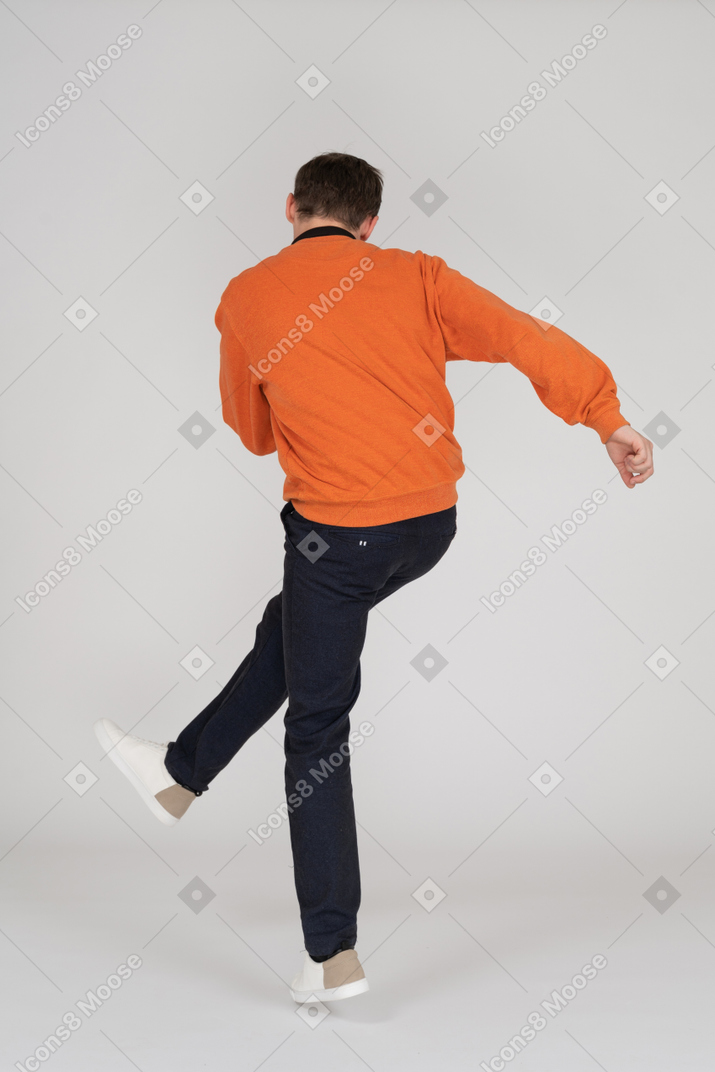 Junger mann im orangefarbenen sweatshirt tanzen