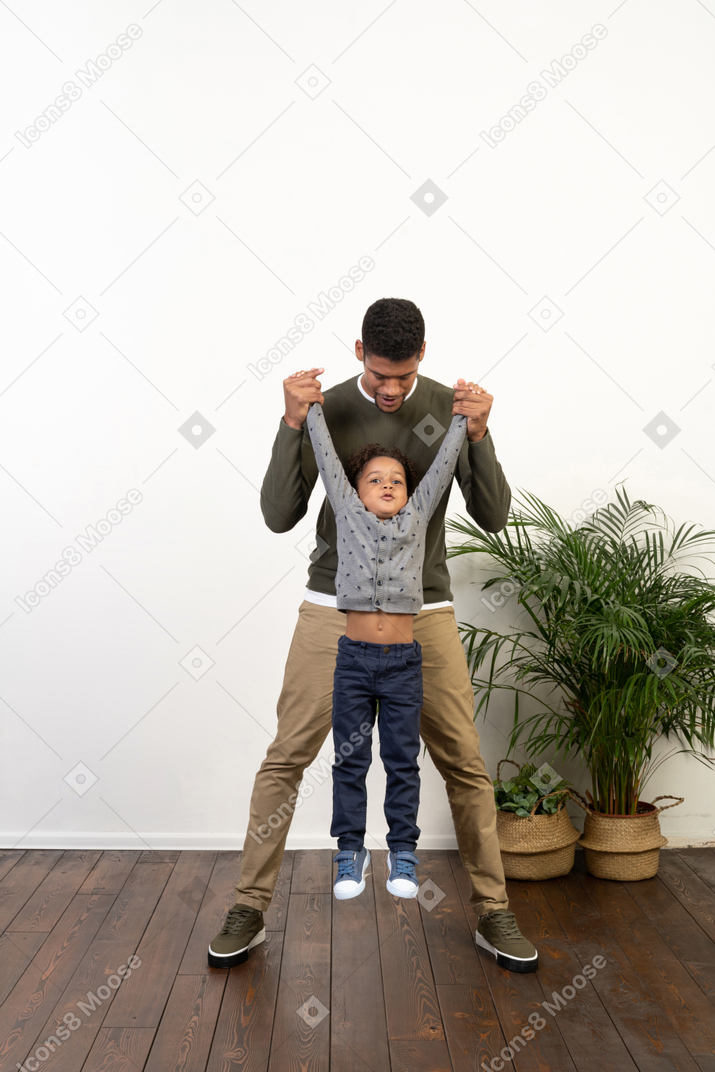 Good looking young man playing with a boy