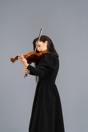 Close-up of a young lady in black dress playing the violin