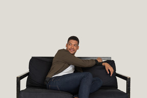 Smiling young man sitting on the sofa