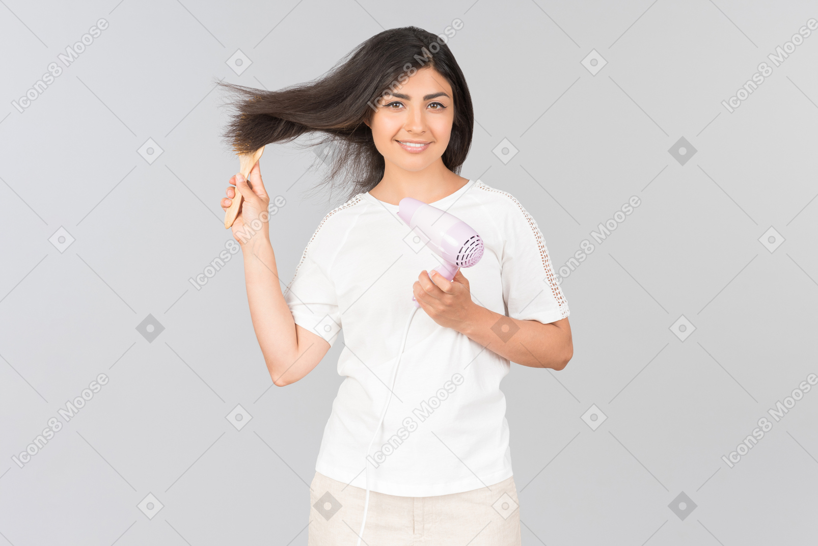 Joven mujer india peinarse con cepillo de pelo y secador de hierro