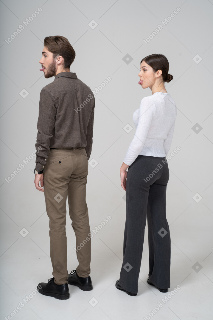 Three-quarter back view of a young couple in office clothing showing tongue