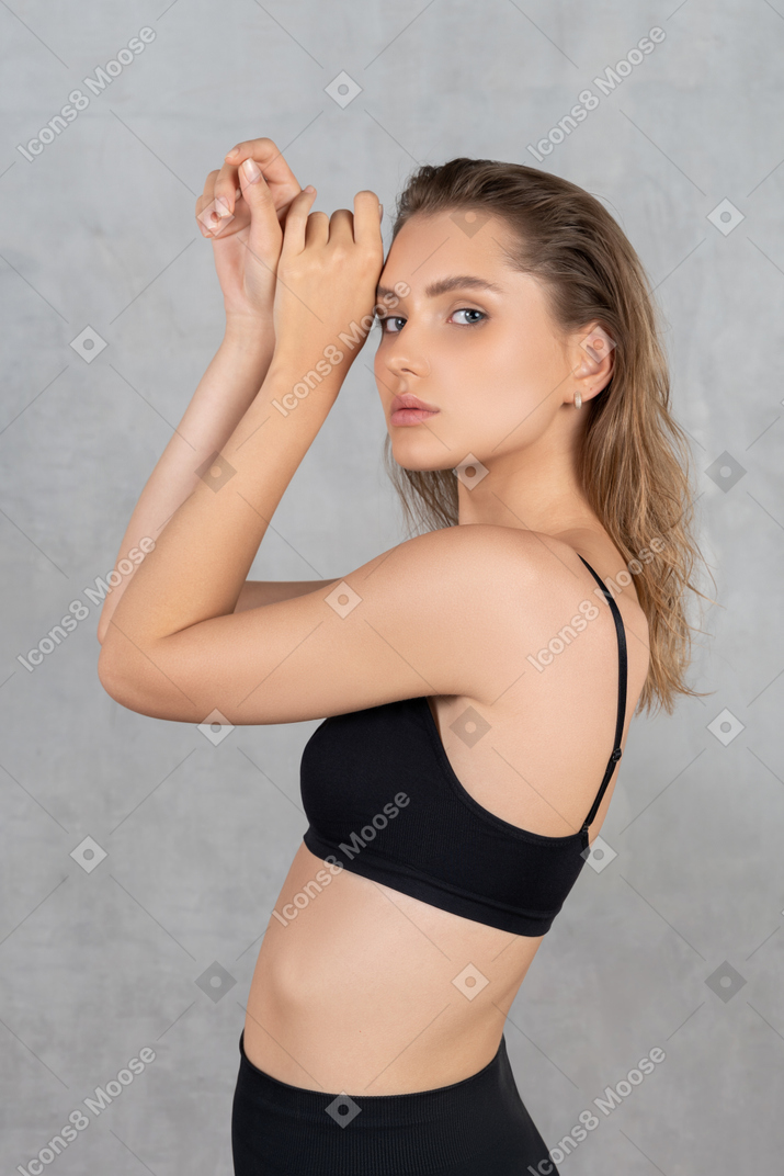 Young attractive woman posing with hands up