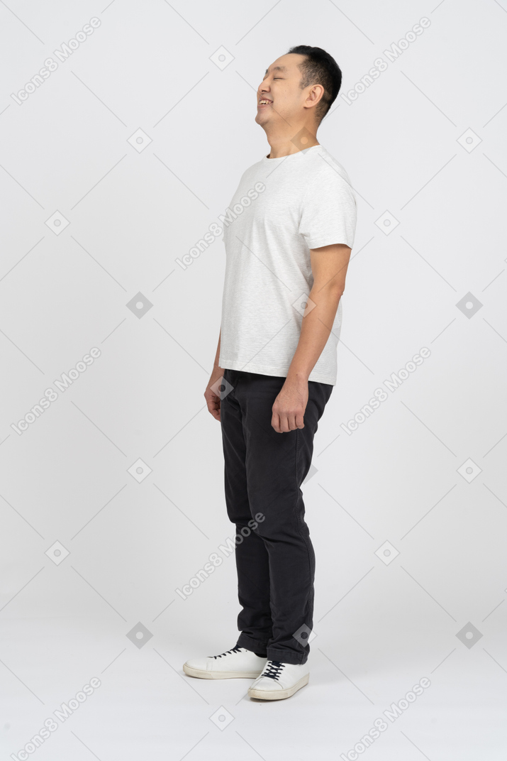 Side view of a happy man in casual clothes looking up