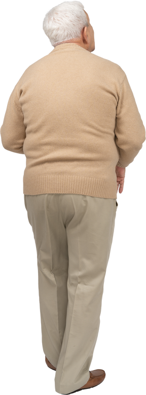 Rear view of an old man in casual clothes looking up