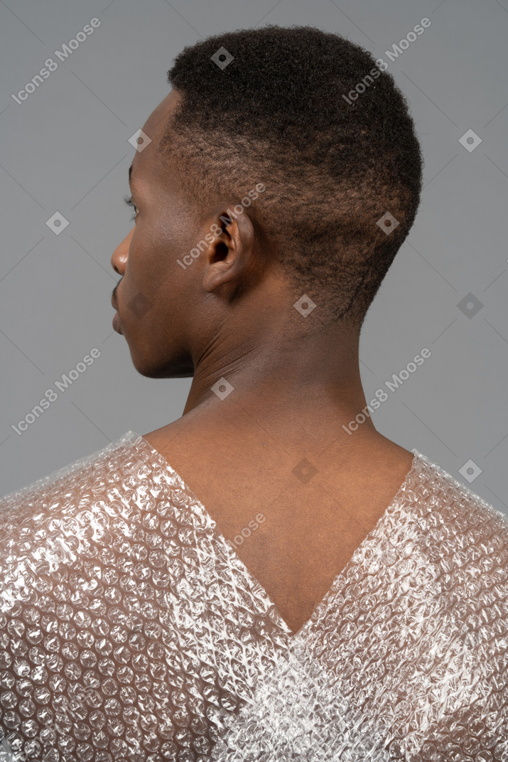 Vista posteriore di un uomo africano con un involucro di plastica che attraversa le spalle