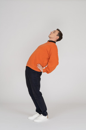 Jeune homme en sweat-shirt orange posant