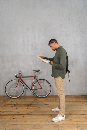 Side view of a man examining a map carefully