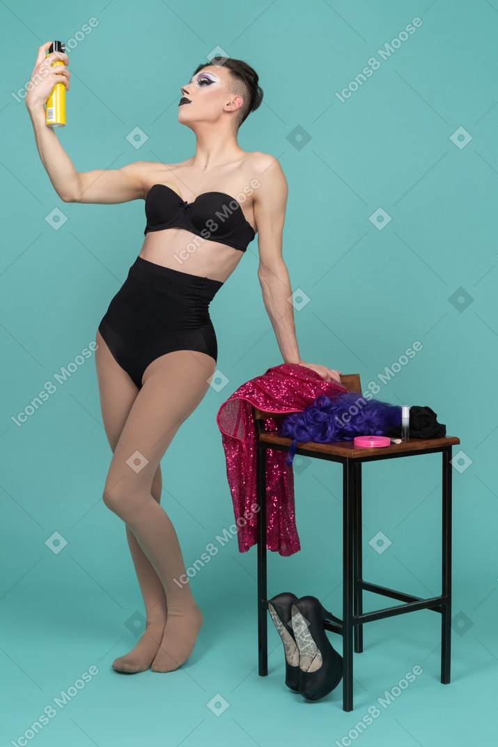 Drag queen in black underwear using hairspray
