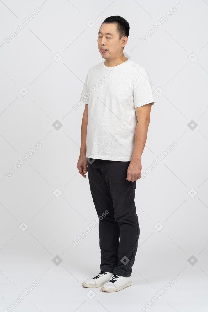 Homem em roupas casuais mostrando a língua