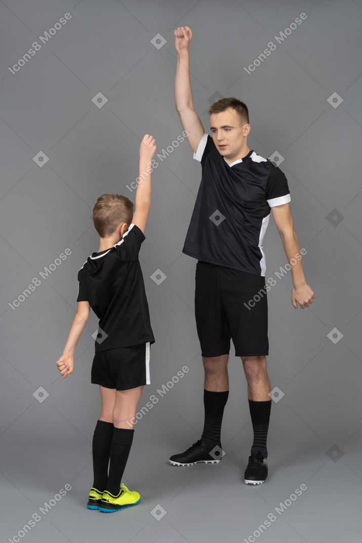 Full-length of a young man coaching little boy making a warm up