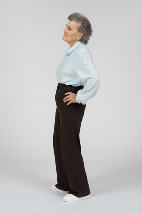 Side view of an old woman looking tired with a hand on the hip