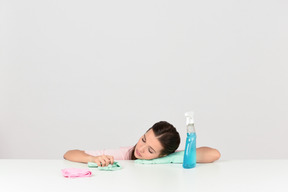 Attractive young woman looking tired while doing household chores