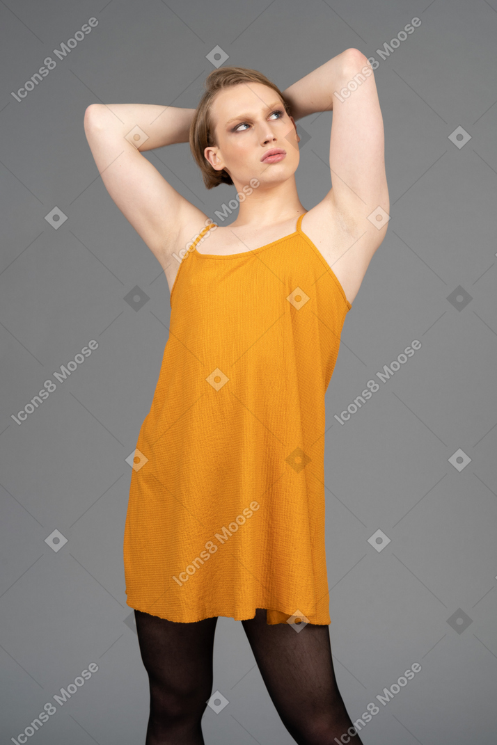Persona genderqueer in posa con le mani dietro la testa