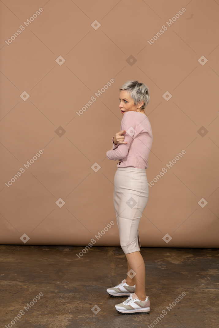 Side view of a woman in casual clothes making faces and hugging herself
