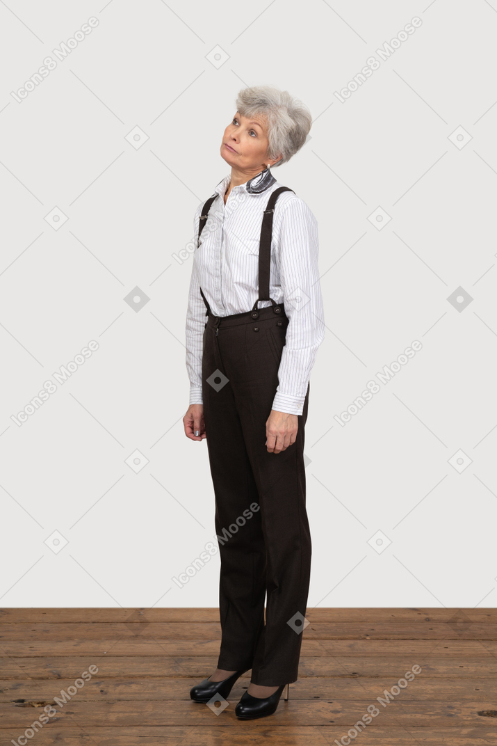Vista de tres cuartos de una anciana descuidada en ropa de oficina