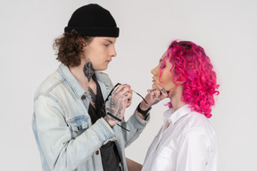 Young tattooed male holding his girlfriend's chin