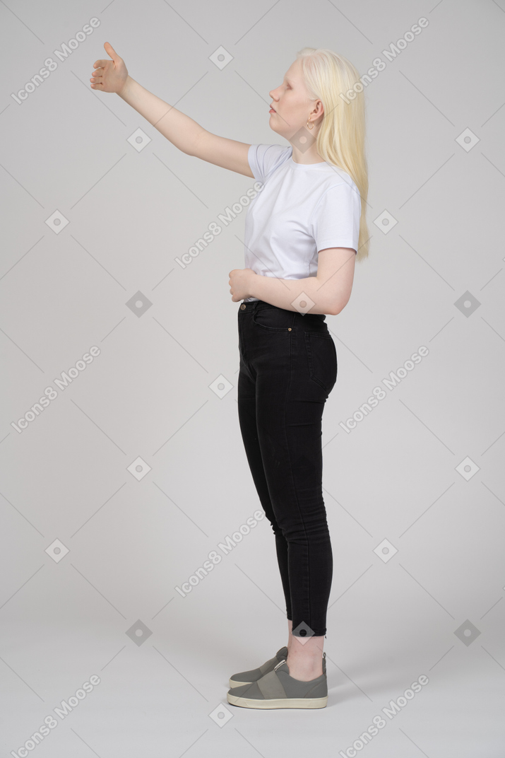Vista lateral de uma mulher de cabelos compridos, levantando o braço