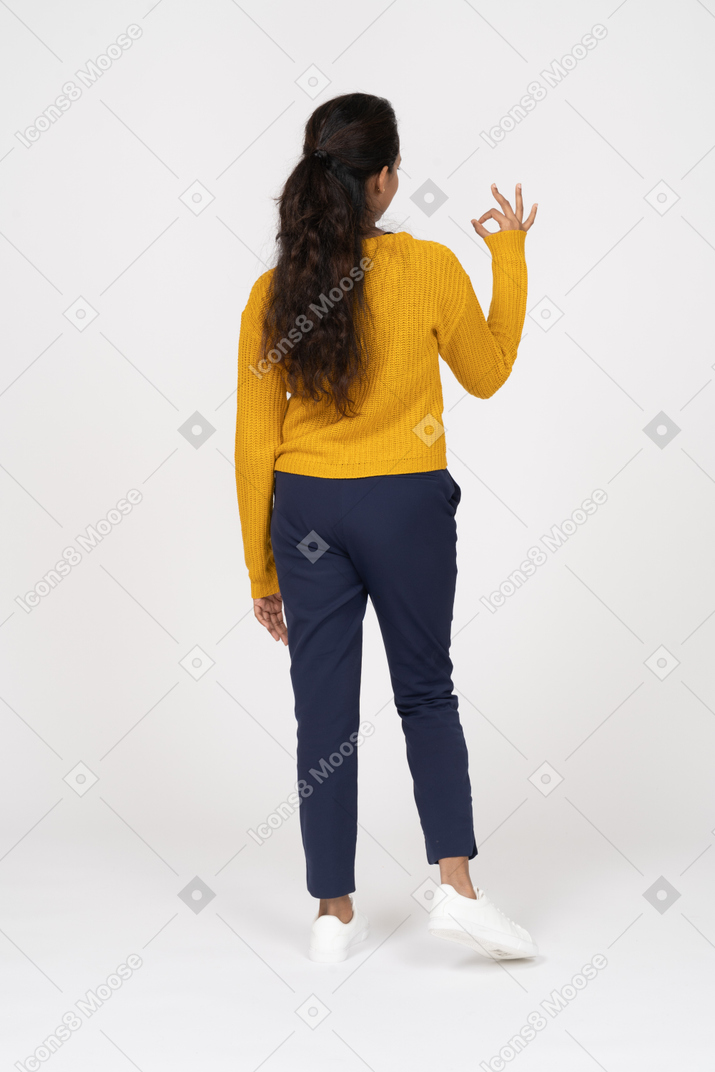 Rear view of a girl in casual clothes showing ok sign