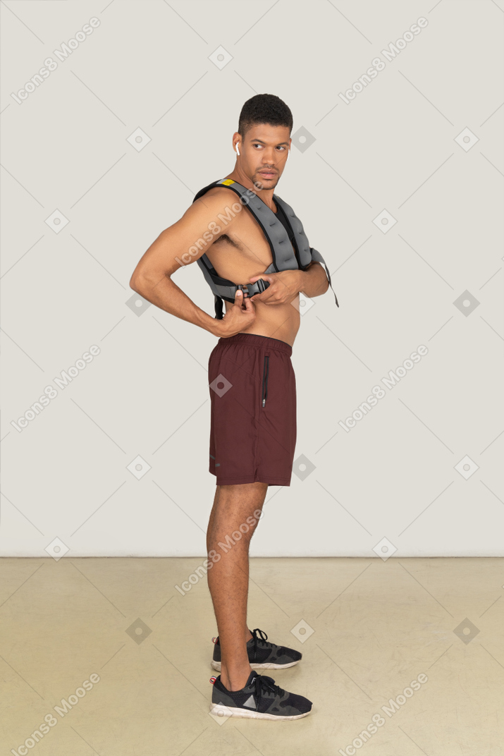Side view of muscular man adjusting weighted vest