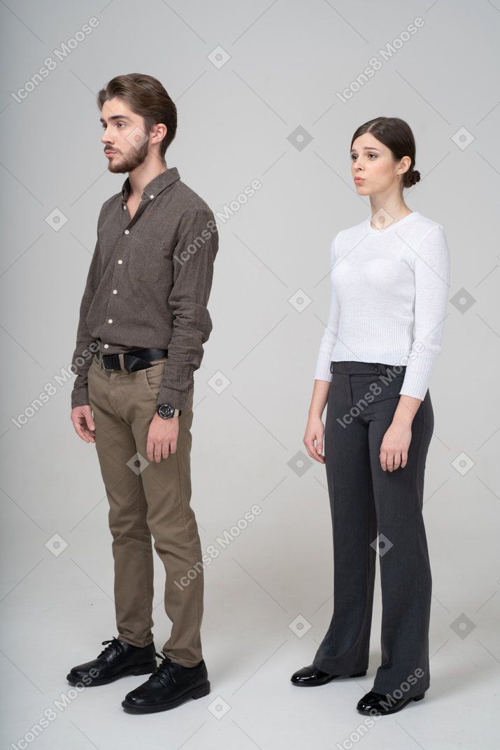 Vue latérale d'un jeune couple en vêtements de bureau debout encore
